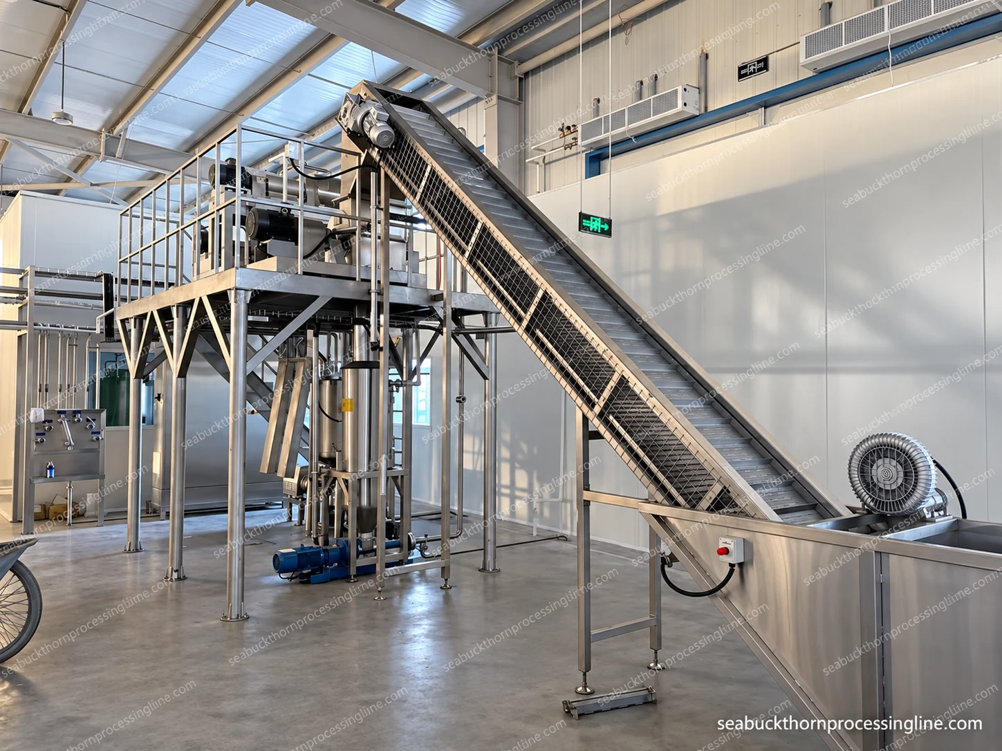 Inclined belt connected to a partly visible wash tank and an elevated platform